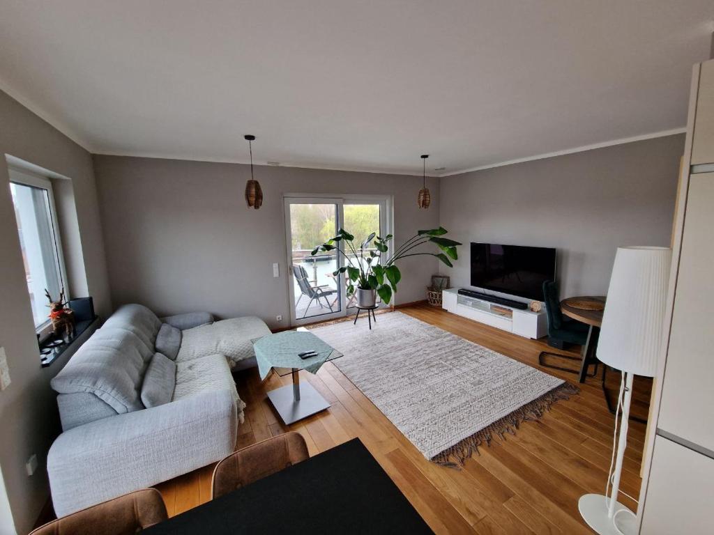 ein Wohnzimmer mit einem Sofa und einem TV in der Unterkunft Luxuriöse 2-Zimmer-Wohnung mit Terrasse, Balkon und Wasserbett in Garbsen