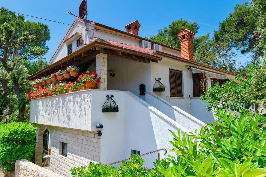 a house with flowers on the side of it at Apartments Marija in Mali Lošinj