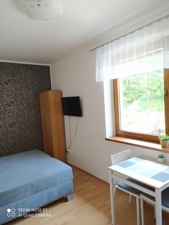 - une chambre avec un lit, une table et une fenêtre dans l'établissement Apartmánový dom Fatrapark 1- Ap 318, Ap 306 Mezonet, à Ružomberok