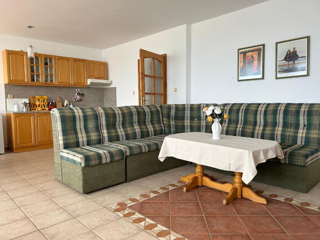 a living room with a couch and a table at Panorama Chantall-izby,apartmány s výhľadom na more in Ravda