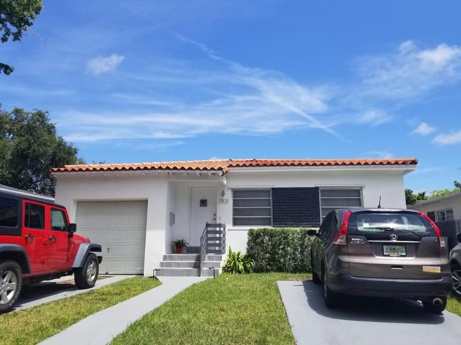 a red truck parked in front of a white house at My lovely home in Miami 15 minutes from the Beach in Miami