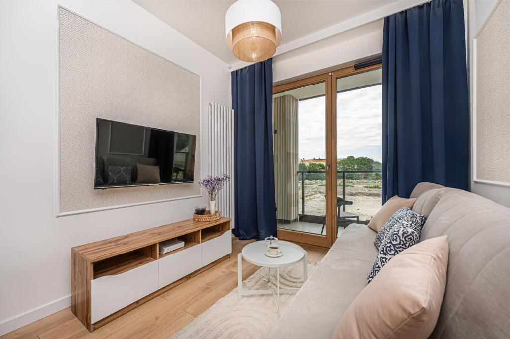 ein Wohnzimmer mit einem Sofa und einem TV in der Unterkunft Porto - BillBerry Apartments in Danzig