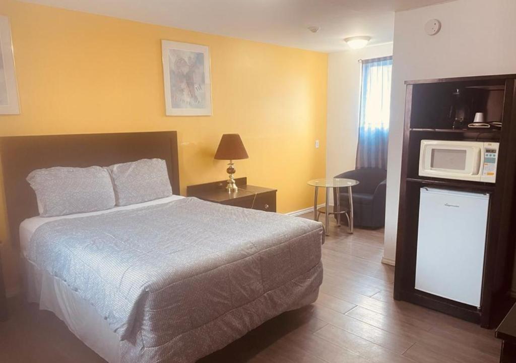 um quarto de hotel com uma cama e um micro-ondas em NORTHERN MOTEL em Sault Ste. Marie