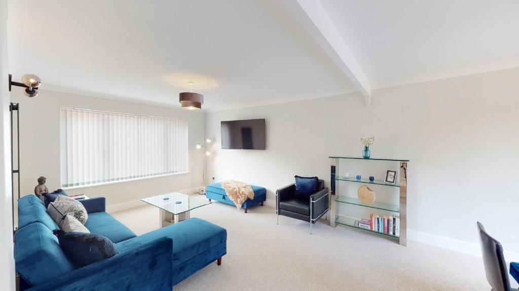 a living room with a blue couch and a table at Mill Stream Passage in Oxford