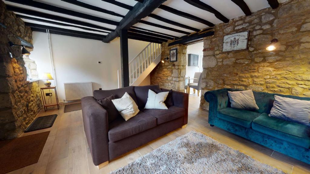 a living room with a couch and a chair at Bushnells Cottage in Oxford