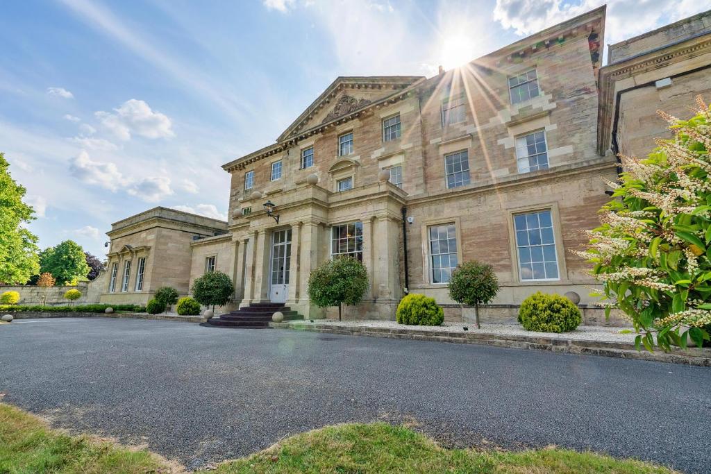 - un grand bâtiment en pierre avec une rue en face dans l'établissement Finest Retreats - Hickleton Hall Estate, à Doncaster