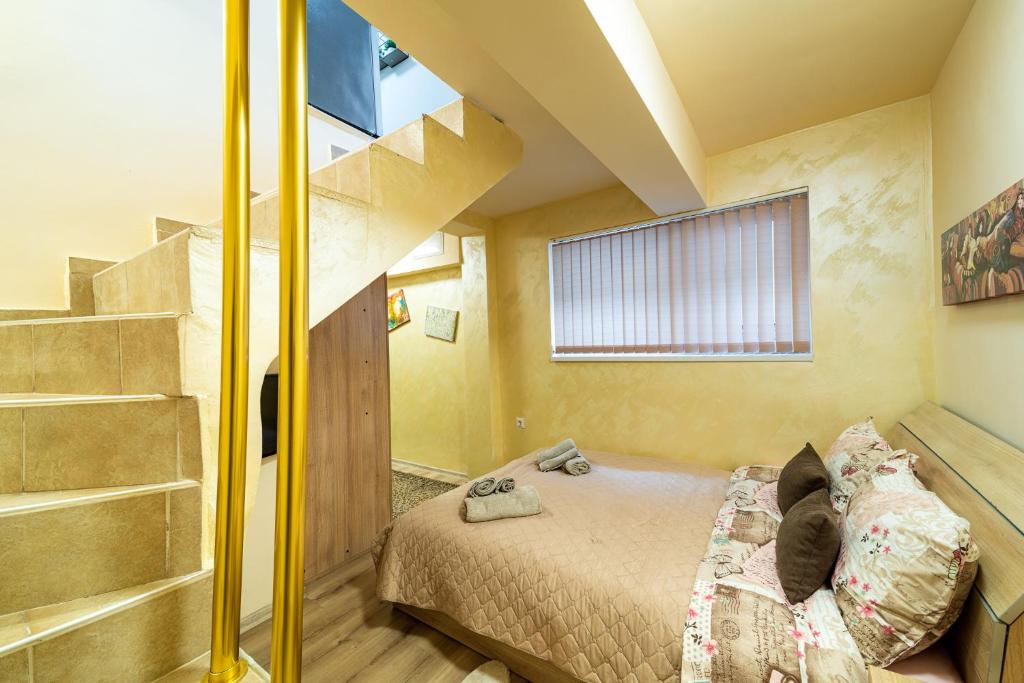 a small bedroom with a bed and a staircase at Abstract Apartment in Varna City