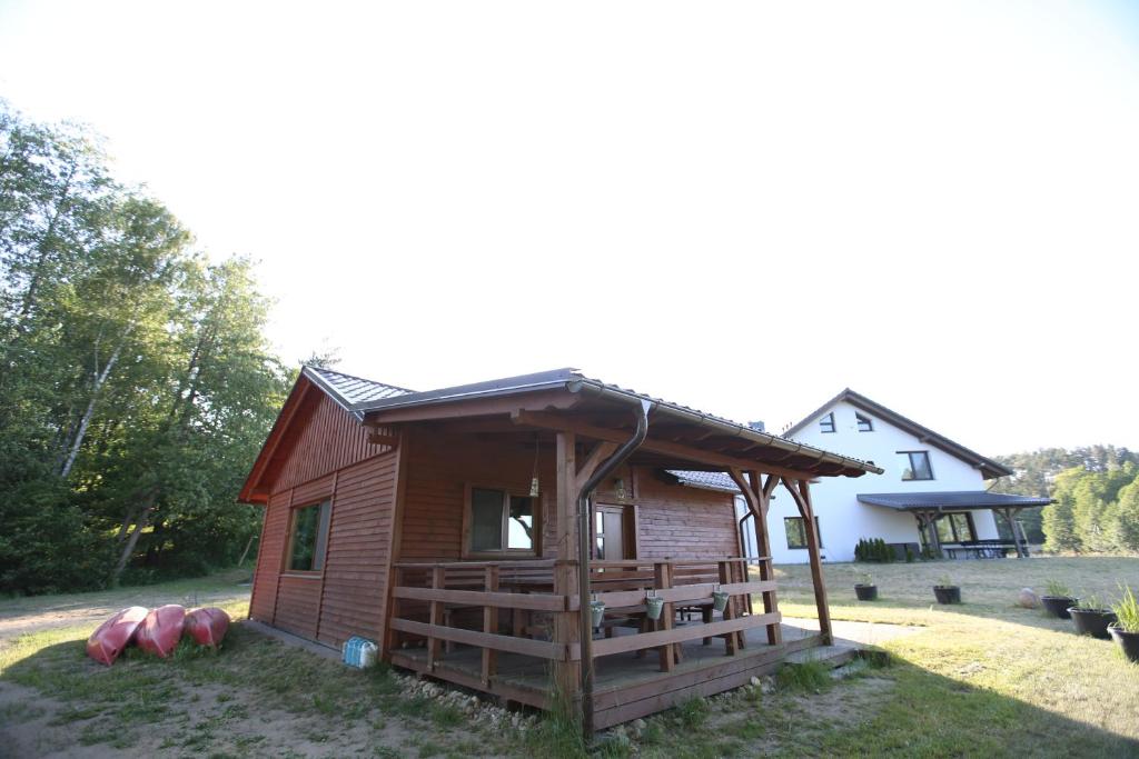 een kleine hut met een veranda en een huis bij Kaszuby To Tu in Parchowo