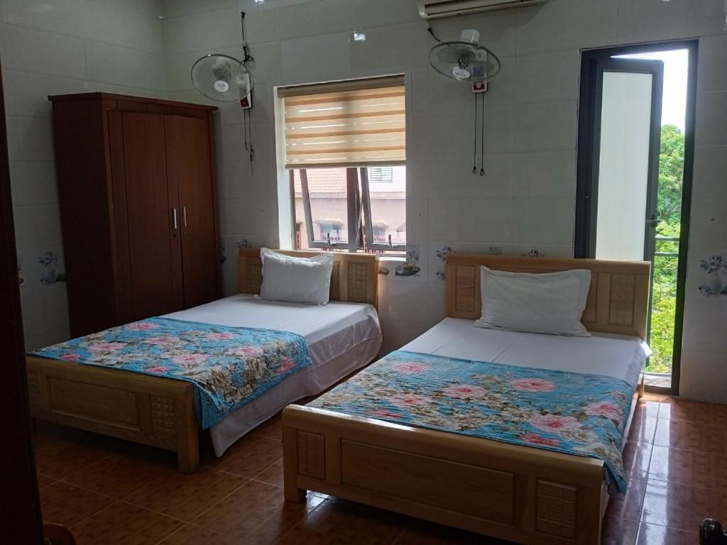 a bedroom with two beds and a window at Hotel Thanh Bình 2 in Ha Tinh