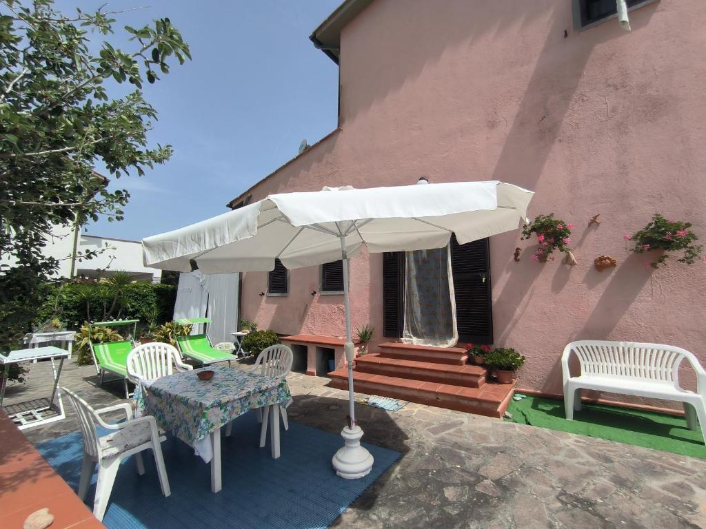 a patio with a table and chairs and an umbrella at Primula by Villa Very in Marina di Campo
