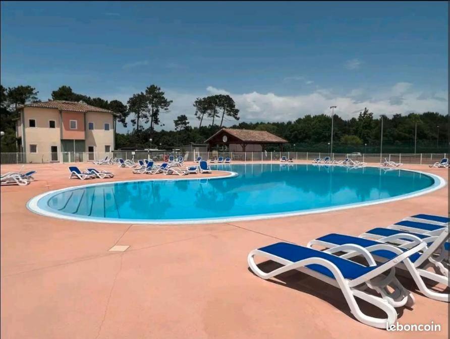 a swimming pool with lounge chairs and a swimming poolvisorvisor at Patrimoine et immobilier Villas du Lac in Soustons