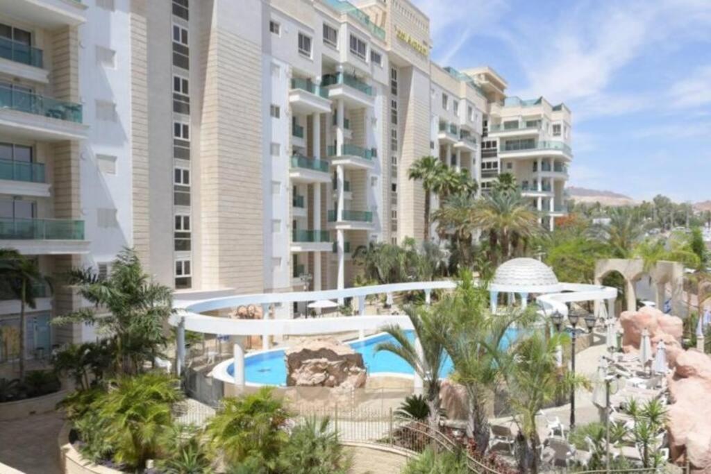 a resort with a swimming pool and some buildings at Modern 2BR APT Golf Residence in Eilat