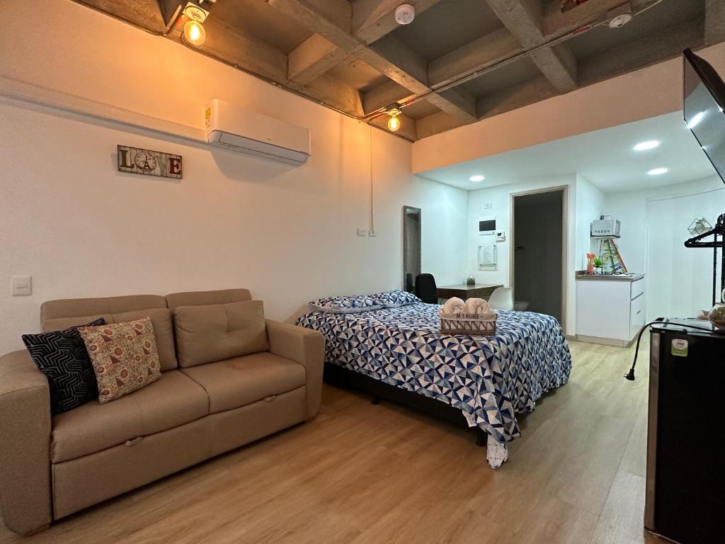 - un salon avec un lit et un canapé dans l'établissement Prime Laureles Location with Air Conditioning, à Medellín