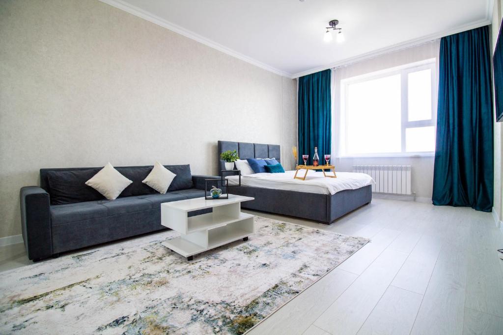 a living room with a couch and a bed at AB Apart Business 64305 in Astana