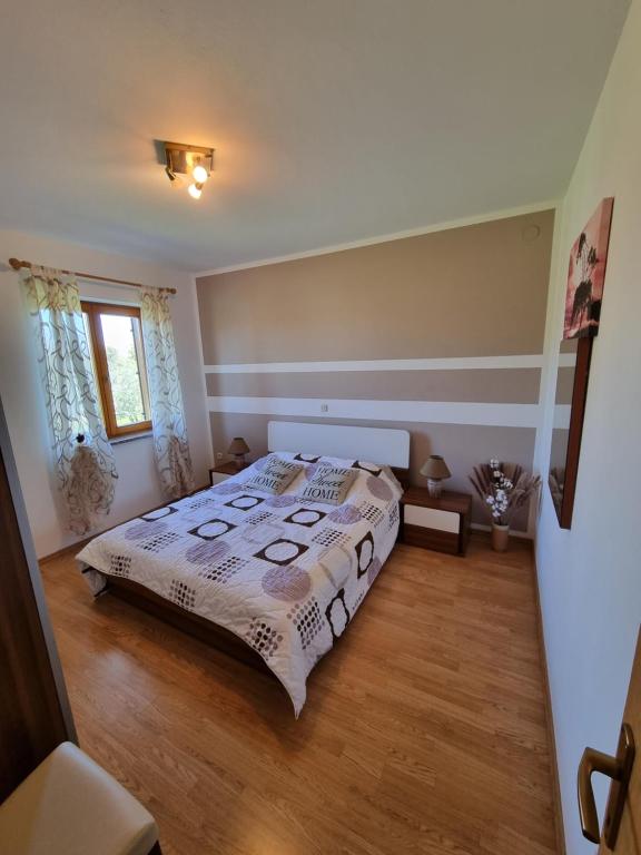 una camera con letto e pavimento in legno di Apartment David a Kavran