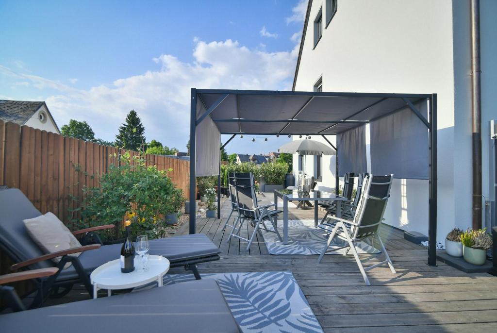 eine Terrasse mit Stühlen und Tischen auf einer Terrasse in der Unterkunft 5 Sterne Traumferienwohnung für 8 Gäste in Selb
