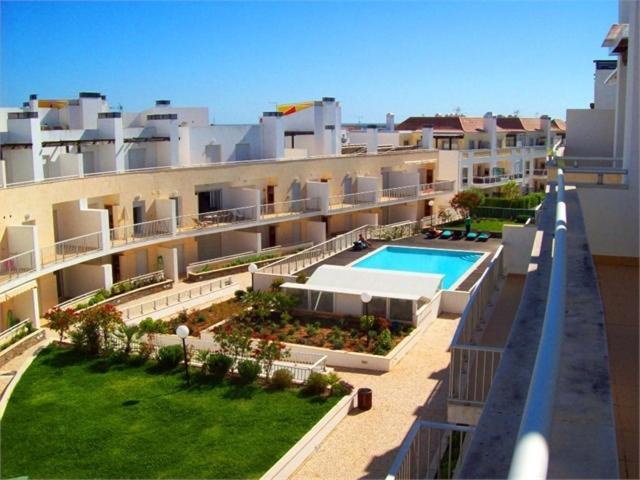 an apartment building with a swimming pool and a yard at Maré Cheia in Tavira
