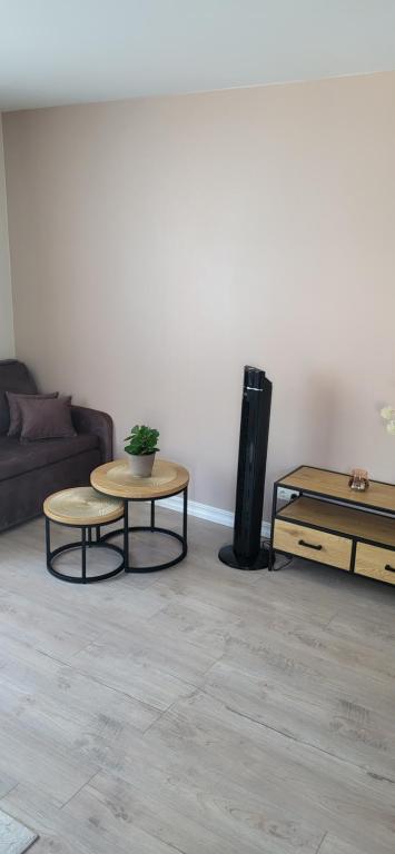 a living room with a couch and two tables at Modern studio apartment near the beach - 5 min walk in Liepāja