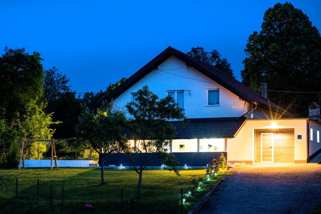 una casa bianca di notte con luci di Apartman Rita a Slunj