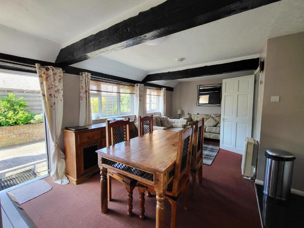 a dining room with a wooden table and a couch at Otters' Lodge in Rooks Bridge