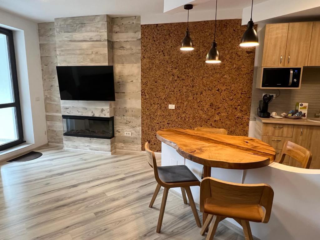 a kitchen with a table and chairs and a fireplace at Coca Apart Mountain View in Sinaia