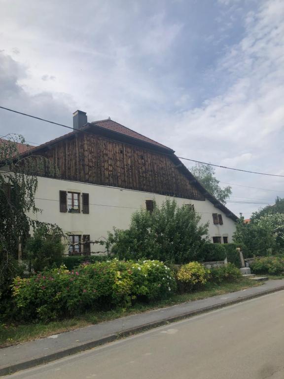un grand bâtiment blanc avec un toit en bois dans l'établissement L’ABSINTHE, à Bannans