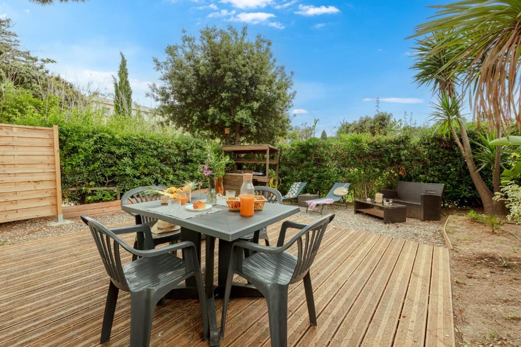 a table and chairs on a wooden deck at La Doucette, mobil-home climatisé au cœur du vignoble et à 50m de la mer in Hyères
