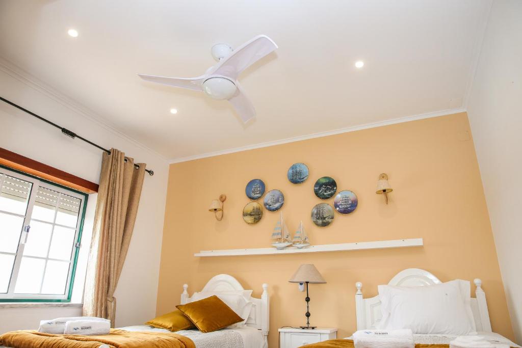 um quarto com 2 camas e uma ventoinha de tecto em Villa House Vasco da Gama - Pool & BQQ - Pata da Gaivota em Lourinhã