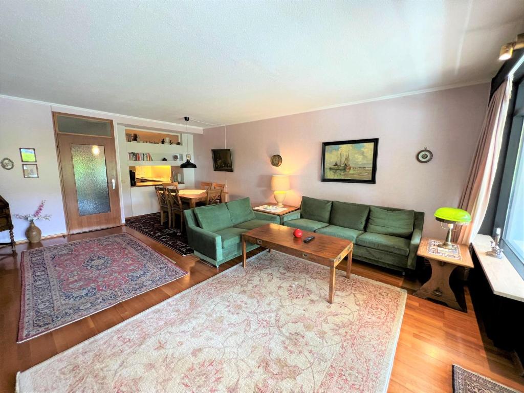 sala de estar con sofá verde y mesa en Ferienpark Sierksdorf App 836 - Strandlage, en Sierksdorf