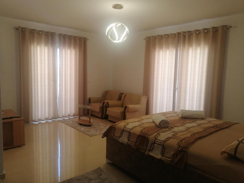 a bedroom with a bed and a couch and a chair at Dizara Apartman's in Ulcinj