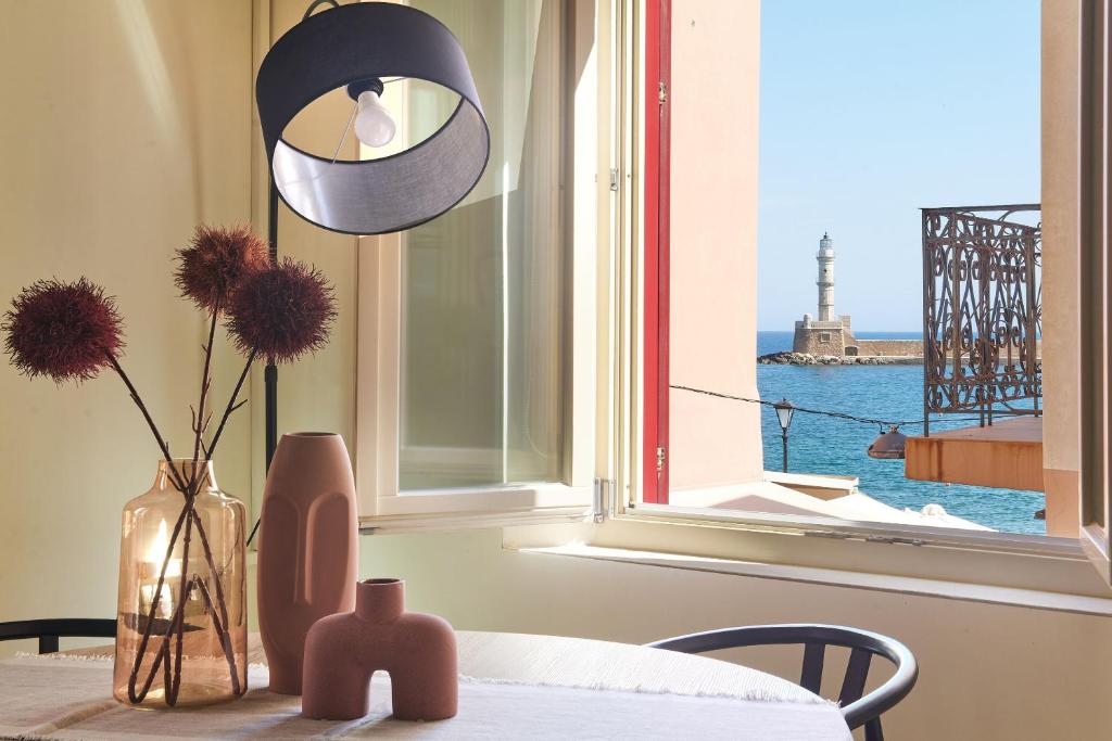 a table with a vase with flowers and a window at Filomeli Estate in Chania