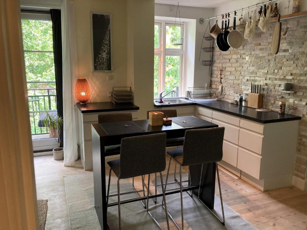 een keuken met een zwarte tafel en stoelen. bij ApartmentInCopenhagen Apartment 1254 in Kopenhagen