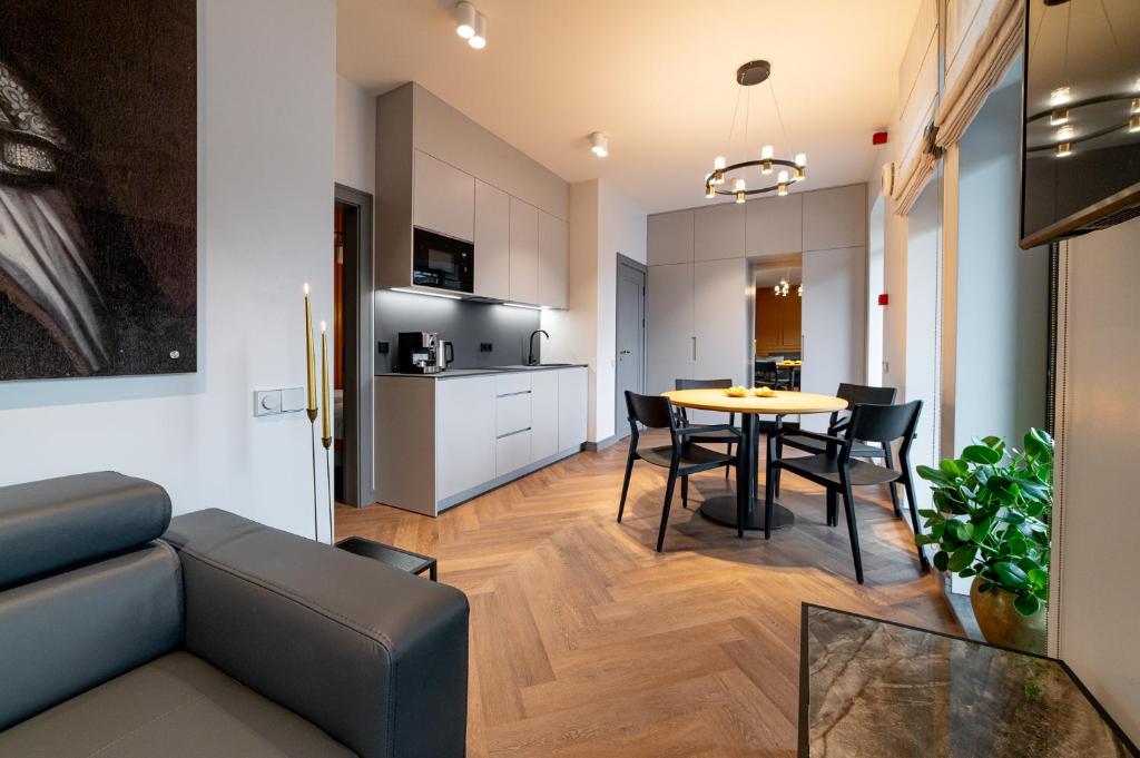 ein Wohnzimmer und eine Küche mit einem Tisch und Stühlen in der Unterkunft Hotel Gothards in Kuldīga