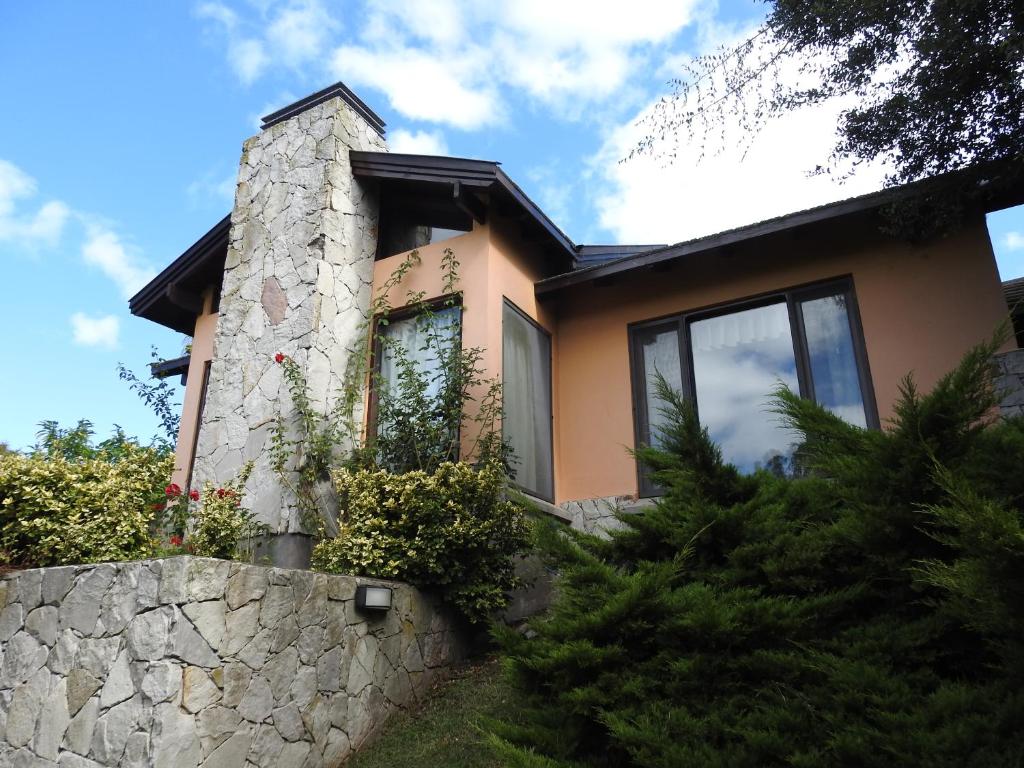 una casa con una pared de piedra delante de ella en Cabañas Kurumamell en Sierra de los Padres