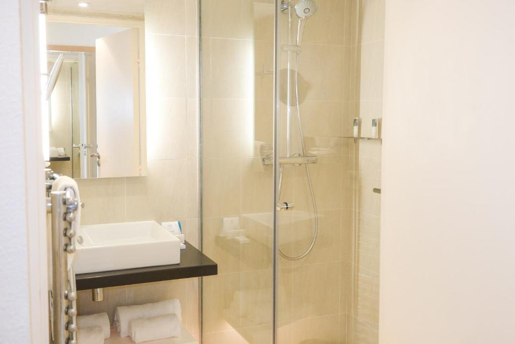 a bathroom with a shower and a sink at Thalazur Ouistreham - Hôtel & Spa in Ouistreham