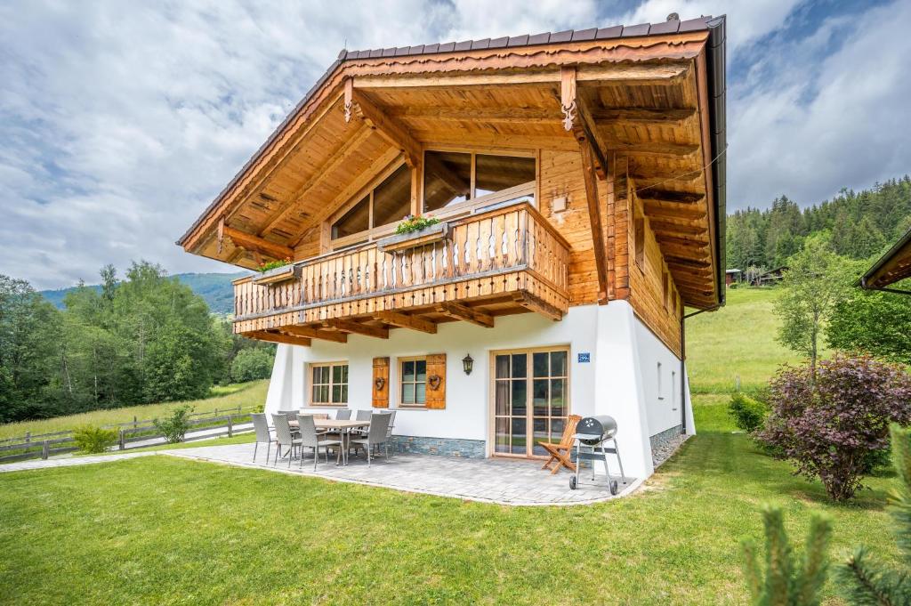 a house with a large deck and a patio at Chalet #1 am Sonnenhang in Neukirchen am Großvenediger