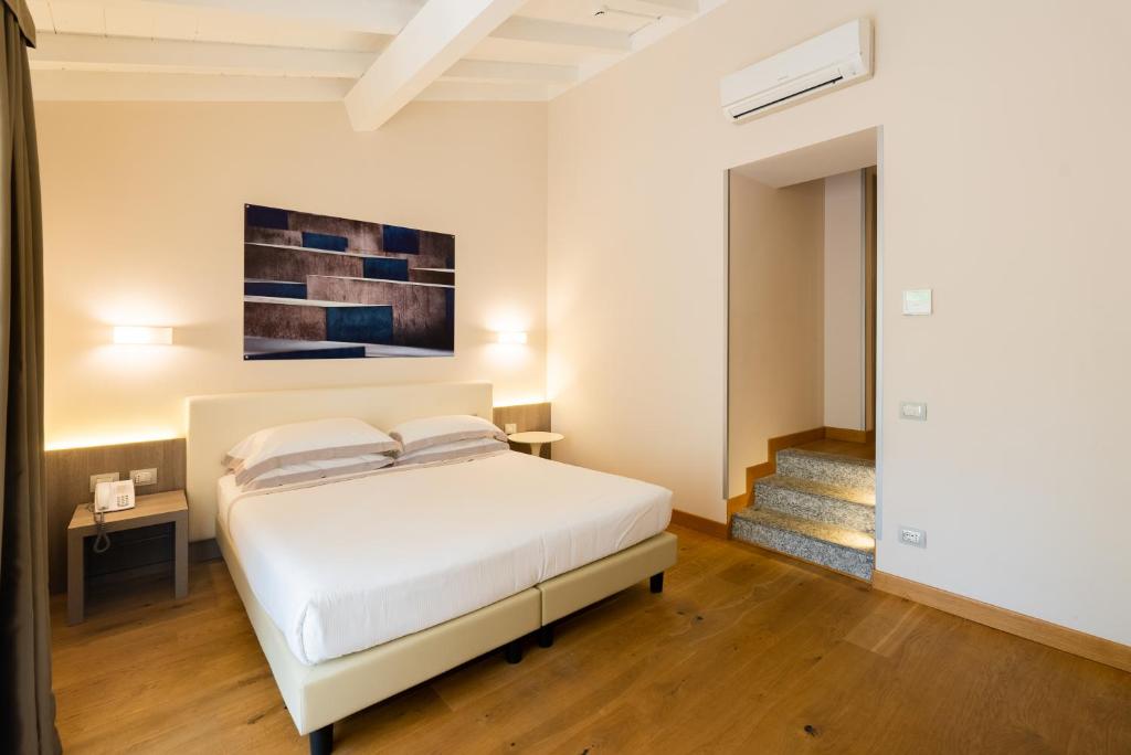 a bedroom with a white bed and a staircase at Hotel Centrale in Cernobbio