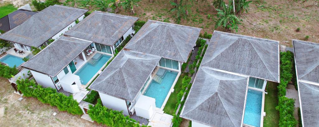 Vue de tête d'une rangée de maisons avec toits dans l'établissement Ahimsa Villas, à Khao Lak