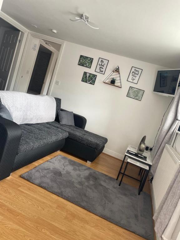 a living room with a couch and pictures on the wall at T-post guest house in South Milford