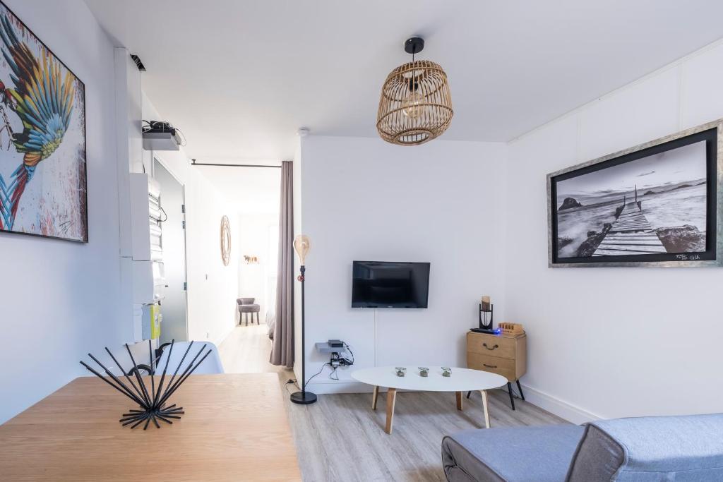 een woonkamer met een bank en een tafel bij Appartement cosy face à la basilique Saint Remi in Reims