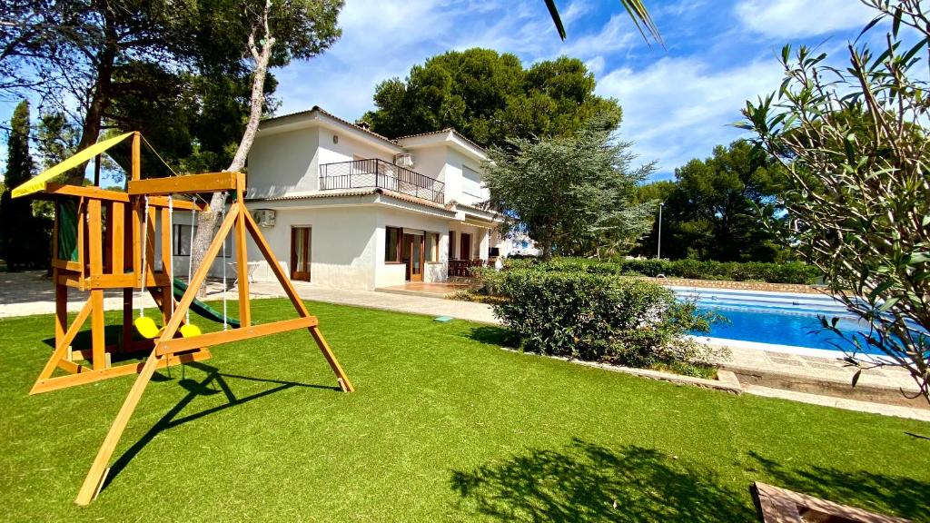 un patio con un columpio y una casa en Villa Yate, en L'Ametlla de Mar