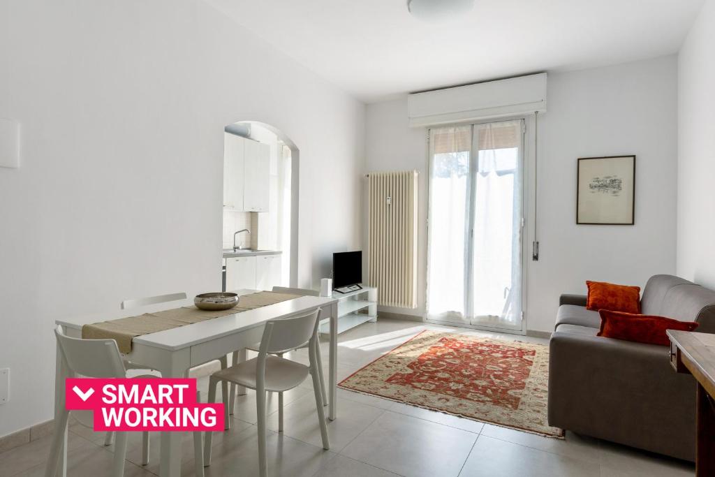 ein weißes Wohnzimmer mit einem Tisch und einem Sofa in der Unterkunft A Casa di Giorgia by Wonderful Italy in Bologna