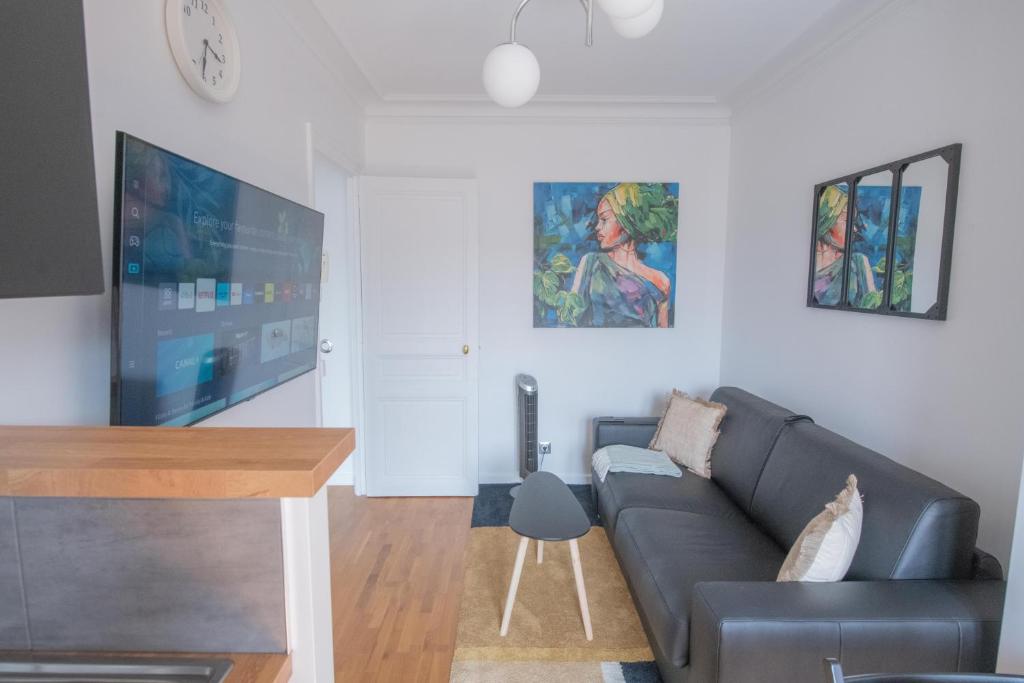 salon z kanapą i telewizorem z płaskim ekranem w obiekcie Paris Bercy - Charming Apartment 2 rooms w Paryżu