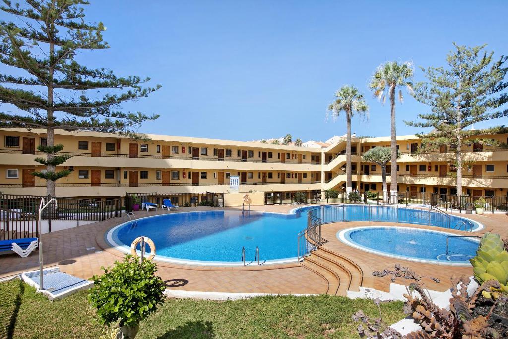 a large swimming pool in front of a building at Estudio Torres del Sol in Playa de las Americas