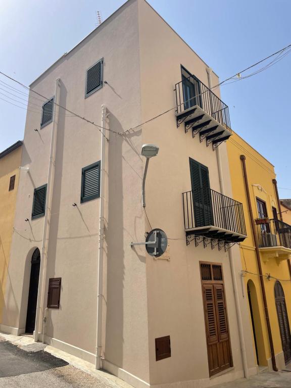a white building with windows and balconies on a street at Zohra in Castellammare del Golfo