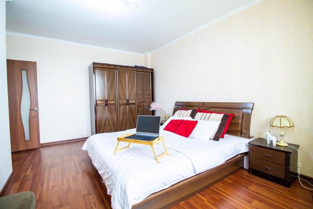 um quarto com uma cama com um computador portátil em AB Apart Business 1b50 em Astana