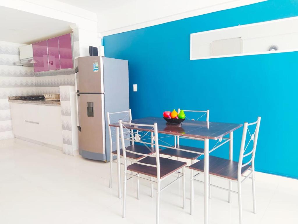 eine Küche mit einem Tisch und Stühlen sowie einem Kühlschrank in der Unterkunft Apartamento cerca al Centro Histórico en Edificio frente a la playa A-3-5 in Cartagena de Indias