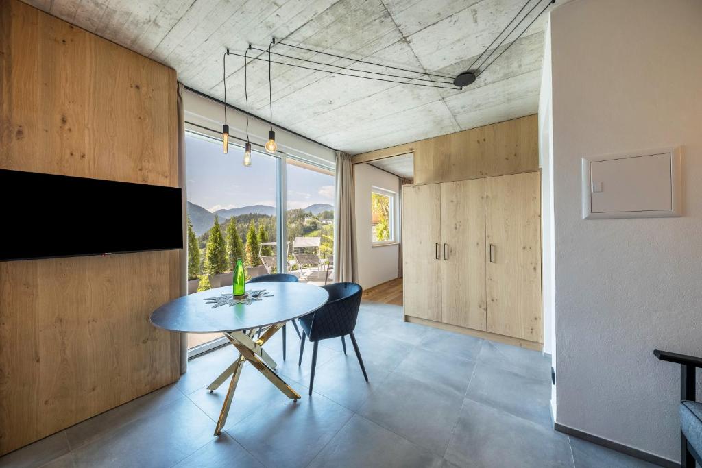 uma sala de jantar com uma mesa e uma grande janela em Thalerhof Naturae Oasis Ritten em Auna di Sotto
