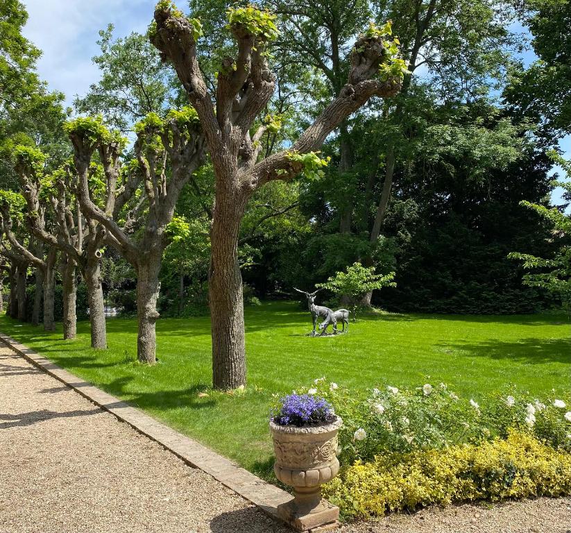 einen Park mit einer Statue eines Hirsches im Gras in der Unterkunft Pavillon époque Napoléon III in Maurecourt