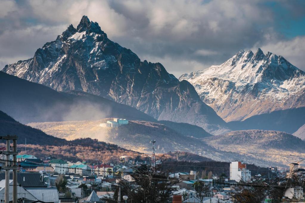 a view of a mountain range with a town and a city at Choconcito Apart Hotel in Ushuaia